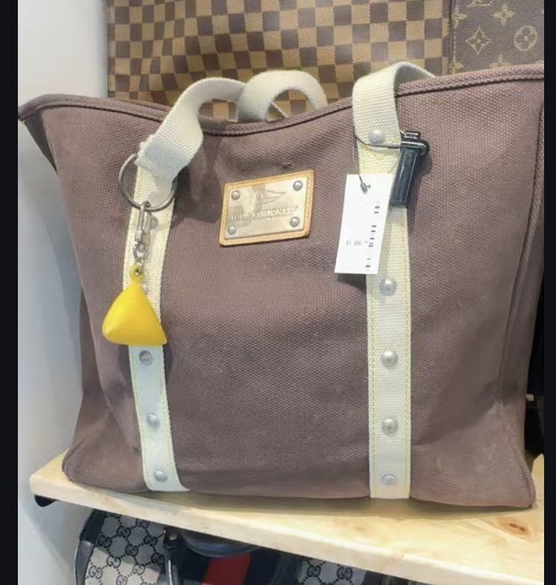 A Louis Vuitton Regatta canvas tote bag with yellow buoy keychain
